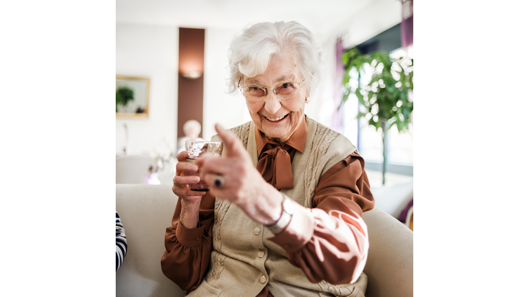 Senior Woman At Sofa Having Fun