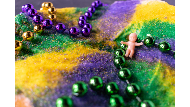 King cake with Mardi Gras beads and baby