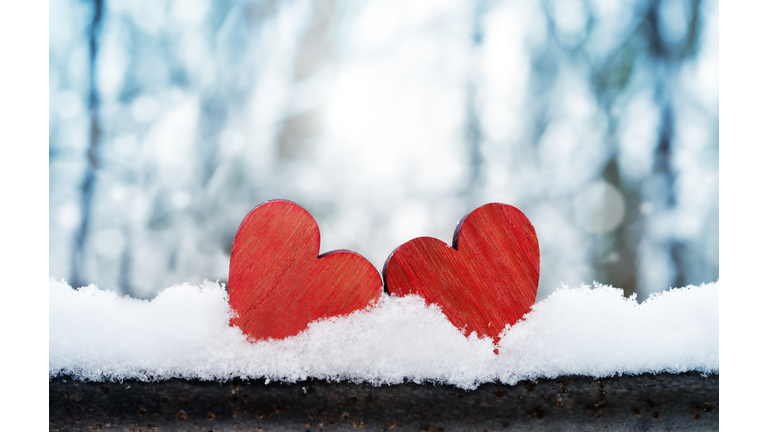 Two beautiful romantic vintage red hearts together on a white snow winter background. Love and St. Valentines Day concept.