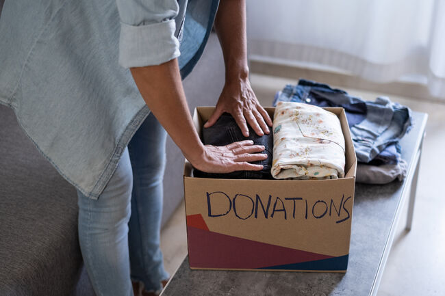 woman preparing boxes of clothes for the donation to charity
