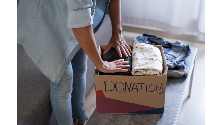 woman preparing boxes of clothes for the donation to charity