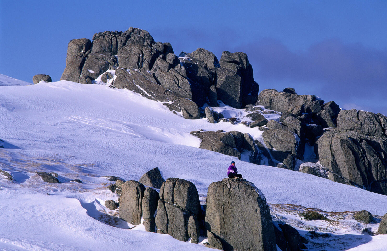 Climber on boulder, Snowy Mountains.