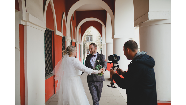 Wedding photographer taking pictures of the bride and groom in a gallery