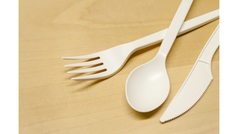 plastic spoon and fork on a wooden table