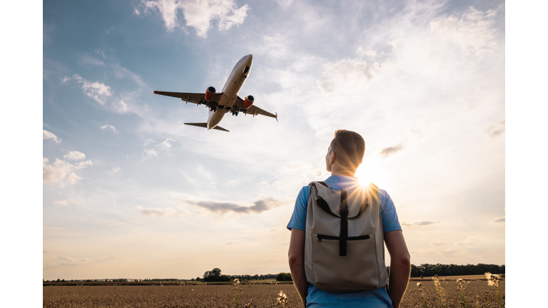 Man looking up to airplane landing