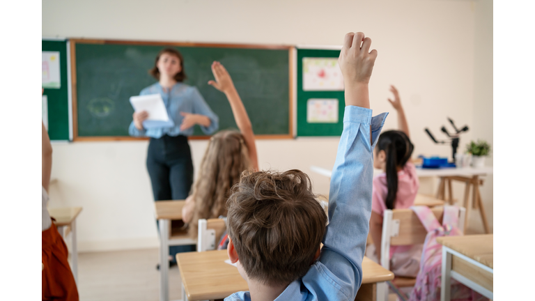 Caucasian young woman teacher teaching student in classroom at school. Attractive beautiful female instructor master explain and educate children with fun activity at preschool nursery kindergarten.