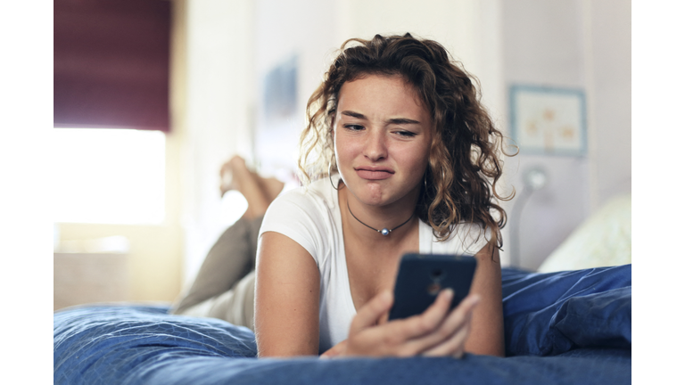 Teenage girl and everyday life. In bed with smartphone