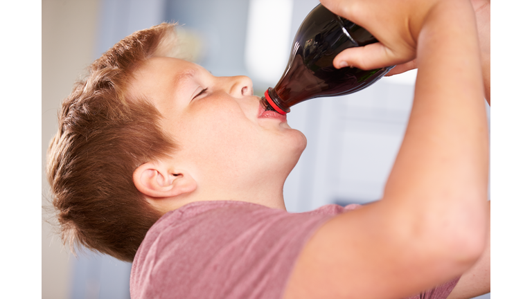 Close Up Of Boy Drinking Soda From Bottle