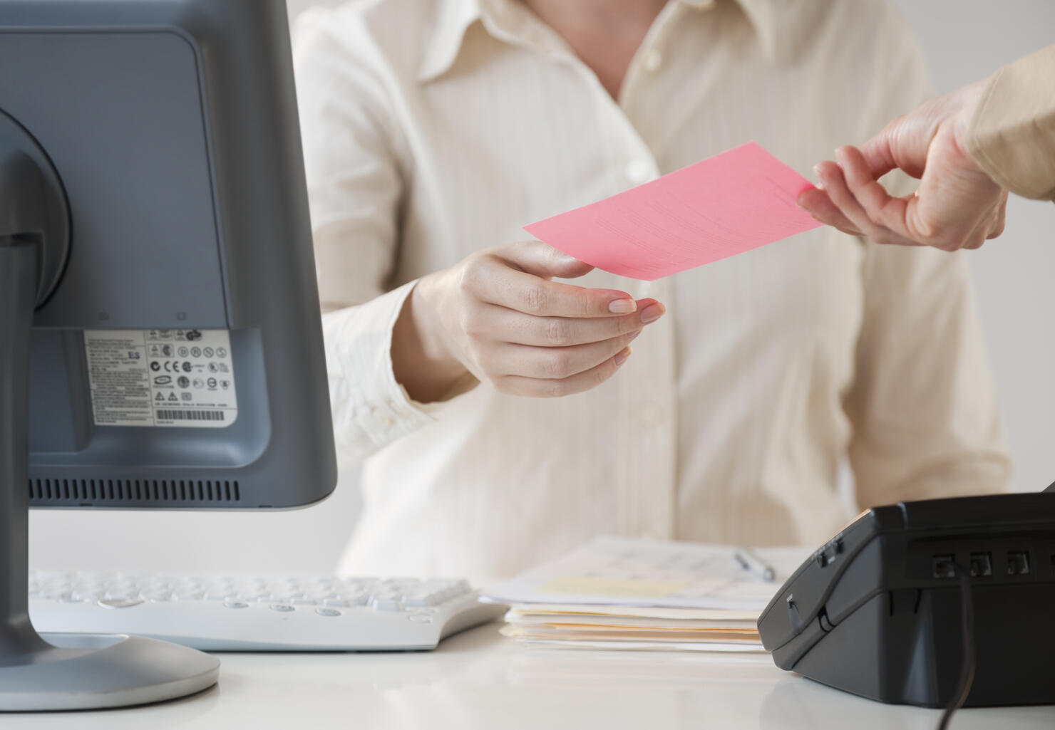 Hand passing note to office worker