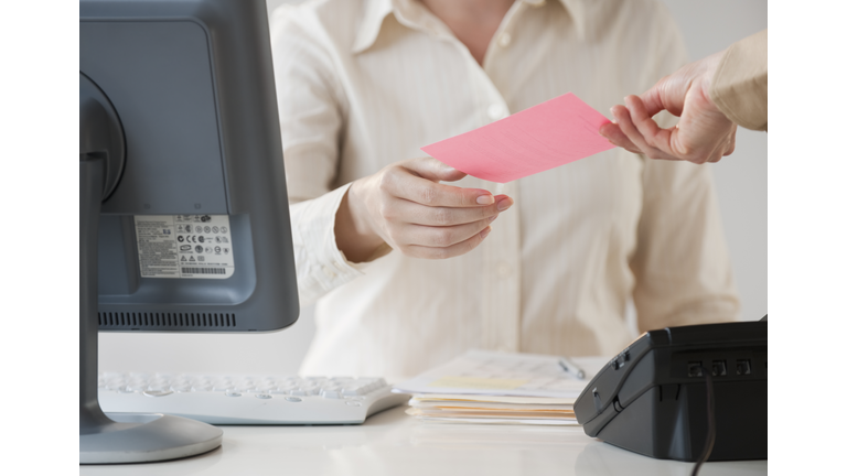 Hand passing note to office worker