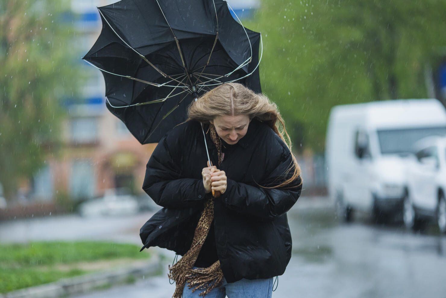 Blonde woman under umbrella. Storm weather. Torrential rain