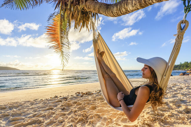 A beautiful woman on a tropical beach, sleeps in a hammock