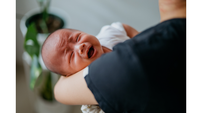 Woman carrying a crying baby