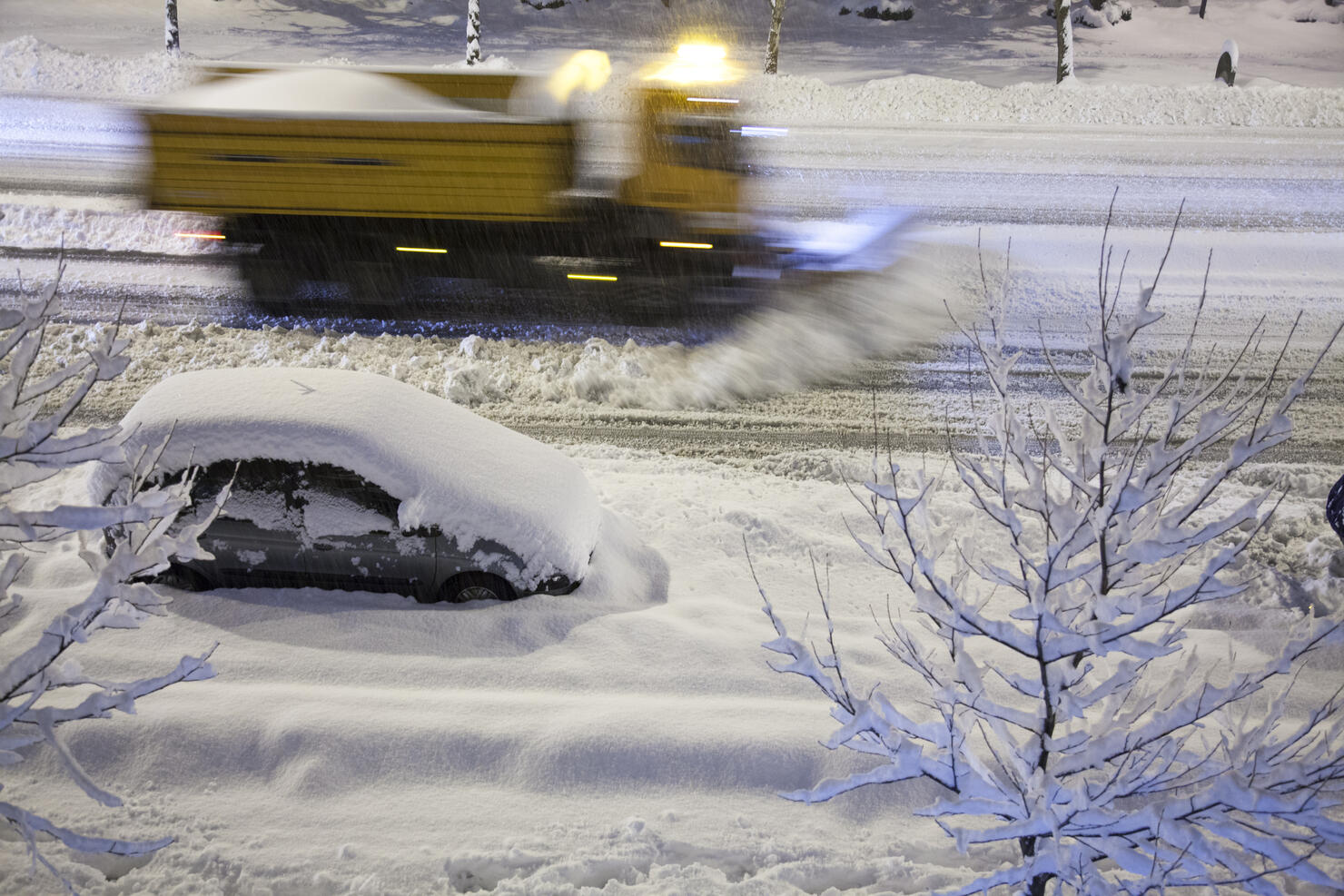 Snowplow removing new snow at night