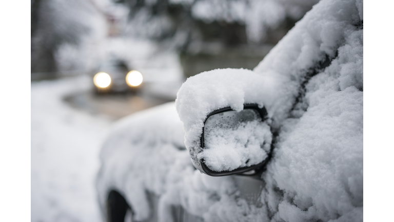 Snow-covered street and car
