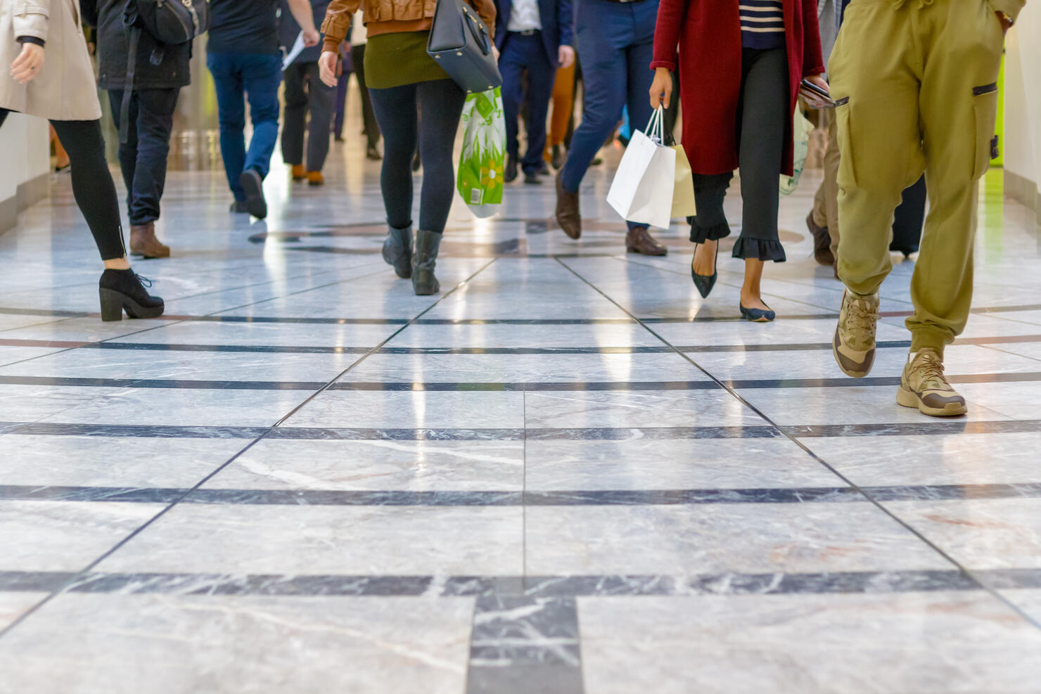 A modern floor with legs of a crowd walking in the background