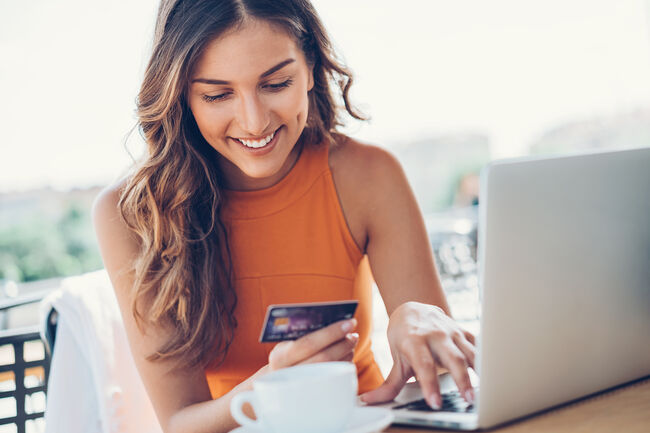 Smiling woman with credit card and laptop