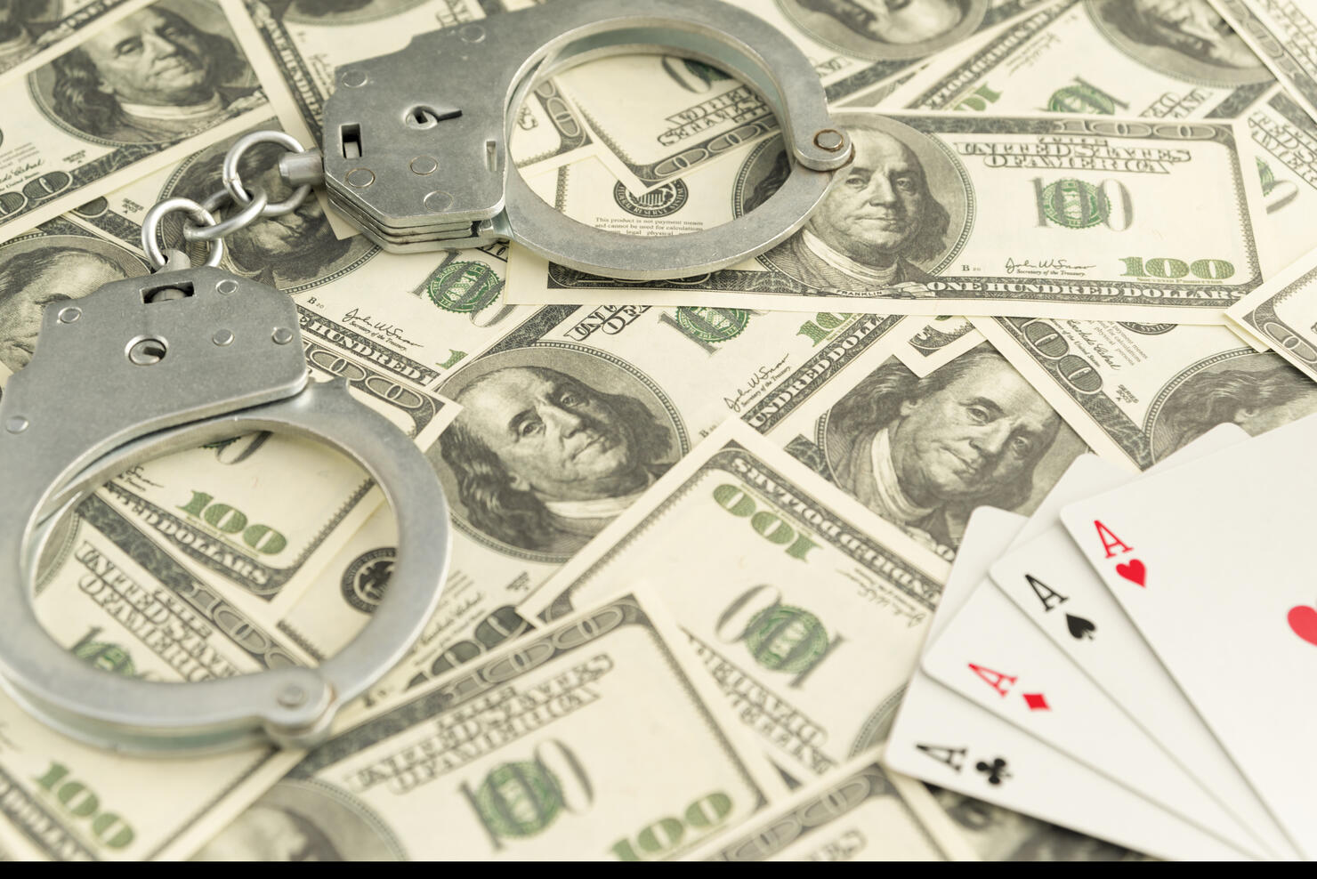 handcuffs, banknotes of dollars, four ace of playing cards.