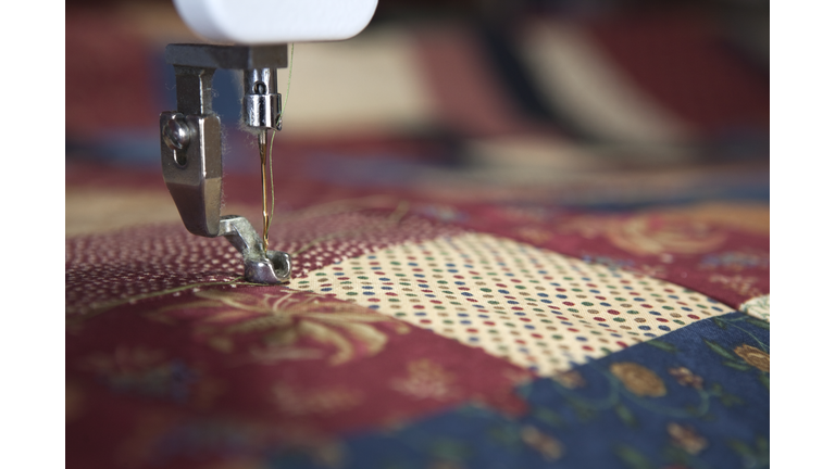 A close up photograph of a needle from a sewing machine