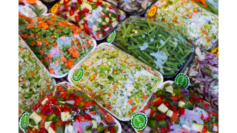 Sets of chopped vegetables wrapped in film on supermarket shelves