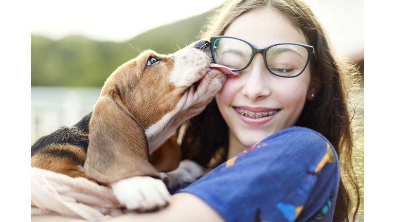 Young girl playing with the dog while giving him a bath