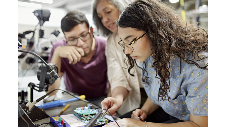 College instructor assisting electrical engineering students