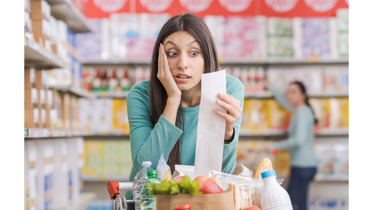 Woman checking an expensive grocery receipt