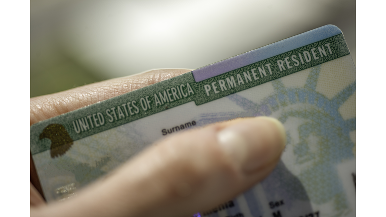 Close up view of Fragment of Permanent resident card (Green) card of USA on blurred background.