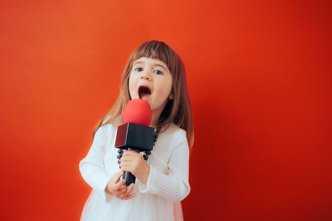 Adorable Toddler Girl Singing Loudly into the Microphone