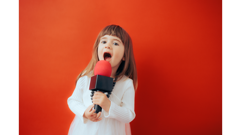 Adorable Toddler Girl Singing Loudly into the Microphone