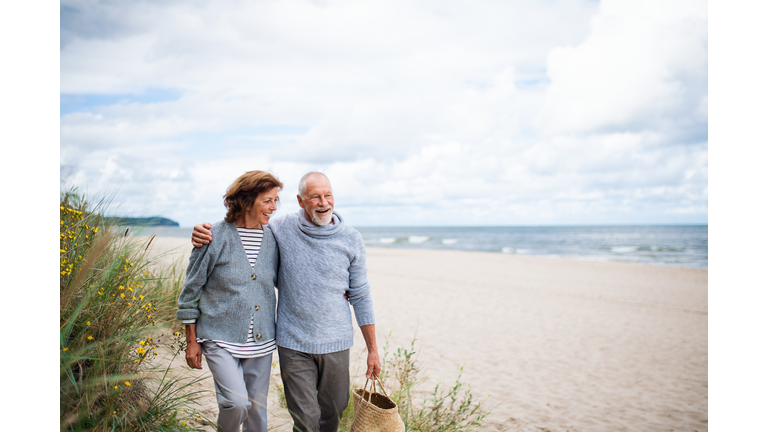 Senior couple in love on walk on beach.