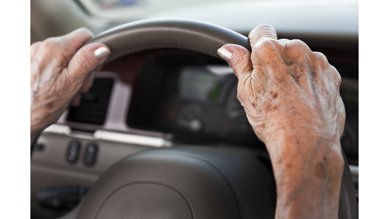 senior woman hands, driving car, steering wheel