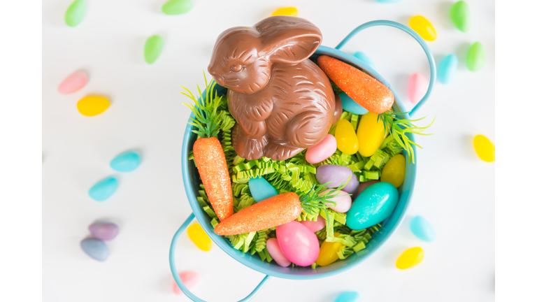 Easter basket filled with Easter grass, candy eggs, mini carrots, and a chocolate rabbit