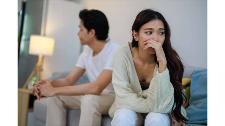 The Asian couple getting upset with each other in bedroom.