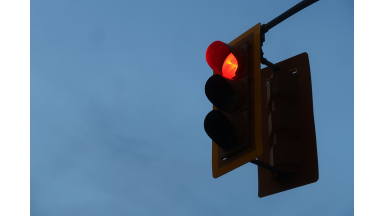 Looking Up at Red Traffic Light against Overcast Sky