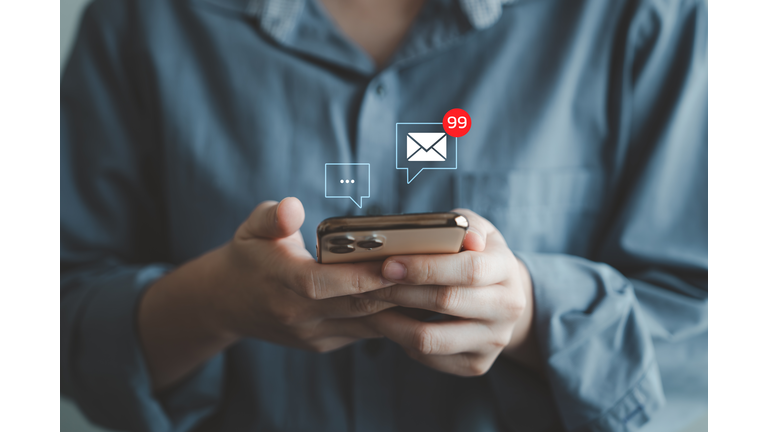 Woman hand using mobile smartphone receive new message and 99 new email alert sign icon pop up.