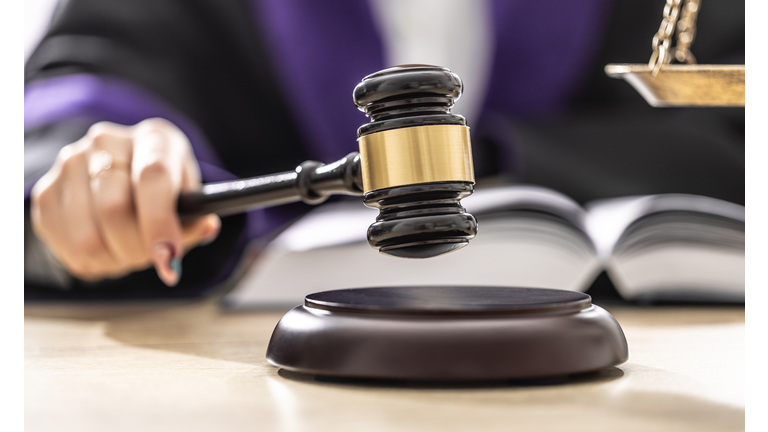 The female judge is taking a final sentence after reading documents and is aboutto hit a gavel on wood.