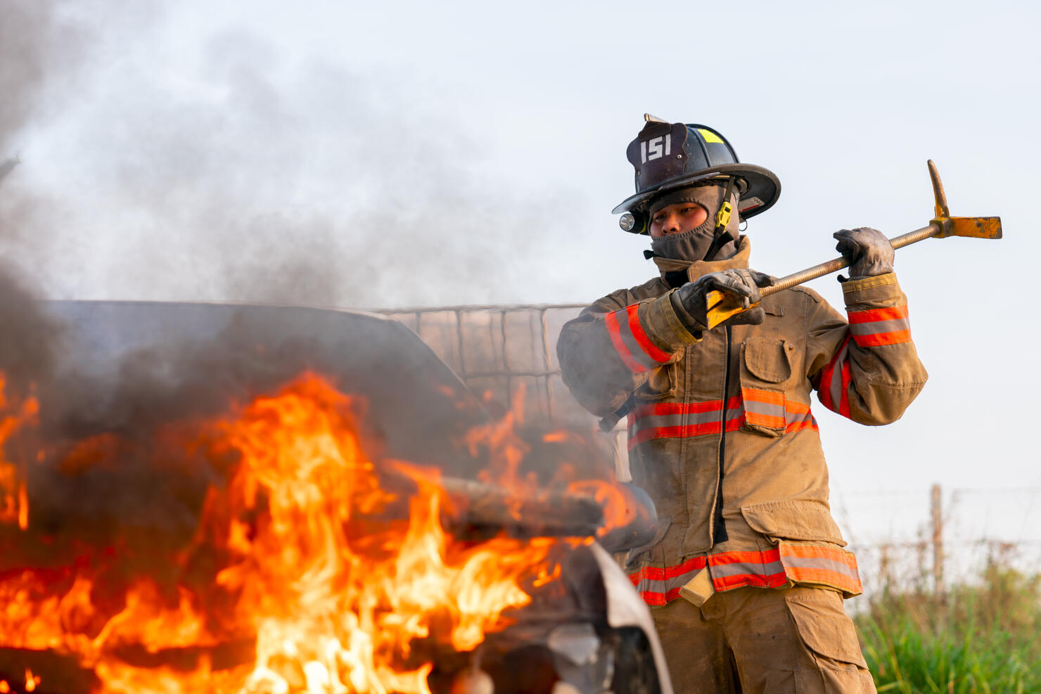 Firefighters rescue victim inside burned car.