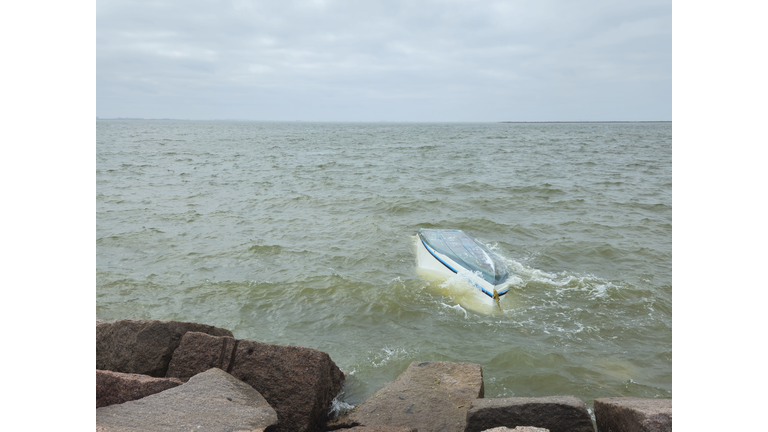 Capsized Boat Near Rocky Coastline