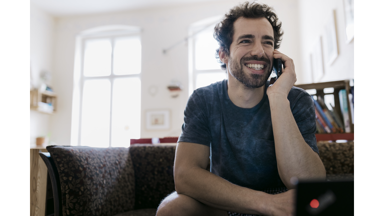 Man Smiling While Talking On Smartphone To Someone