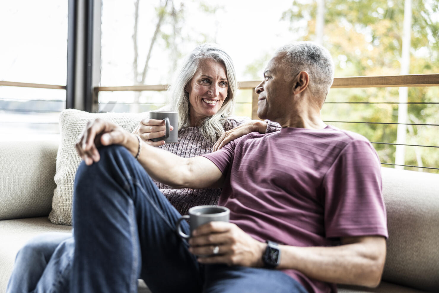 Senior couple having coffee and embracing on back porch of vacation home