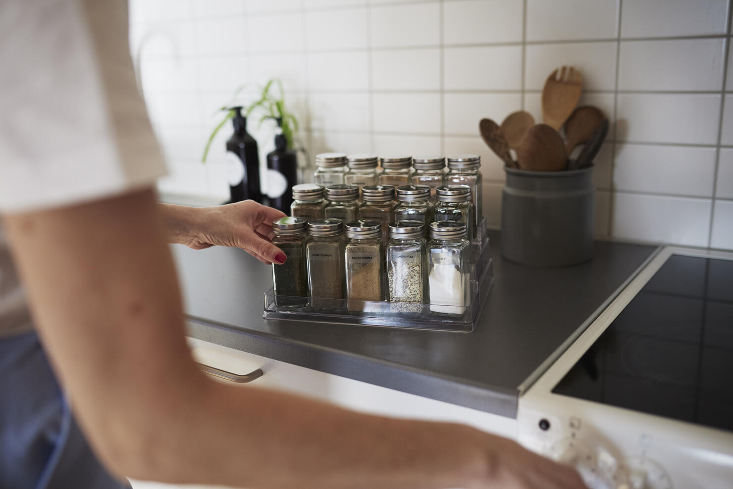 Woman's hands checking spices on spice rack