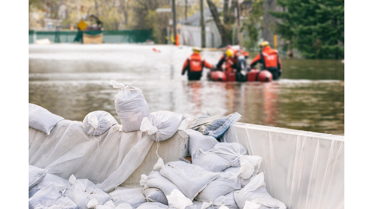 Flood Protection Sandbags with flooded homes in the background (Montage)