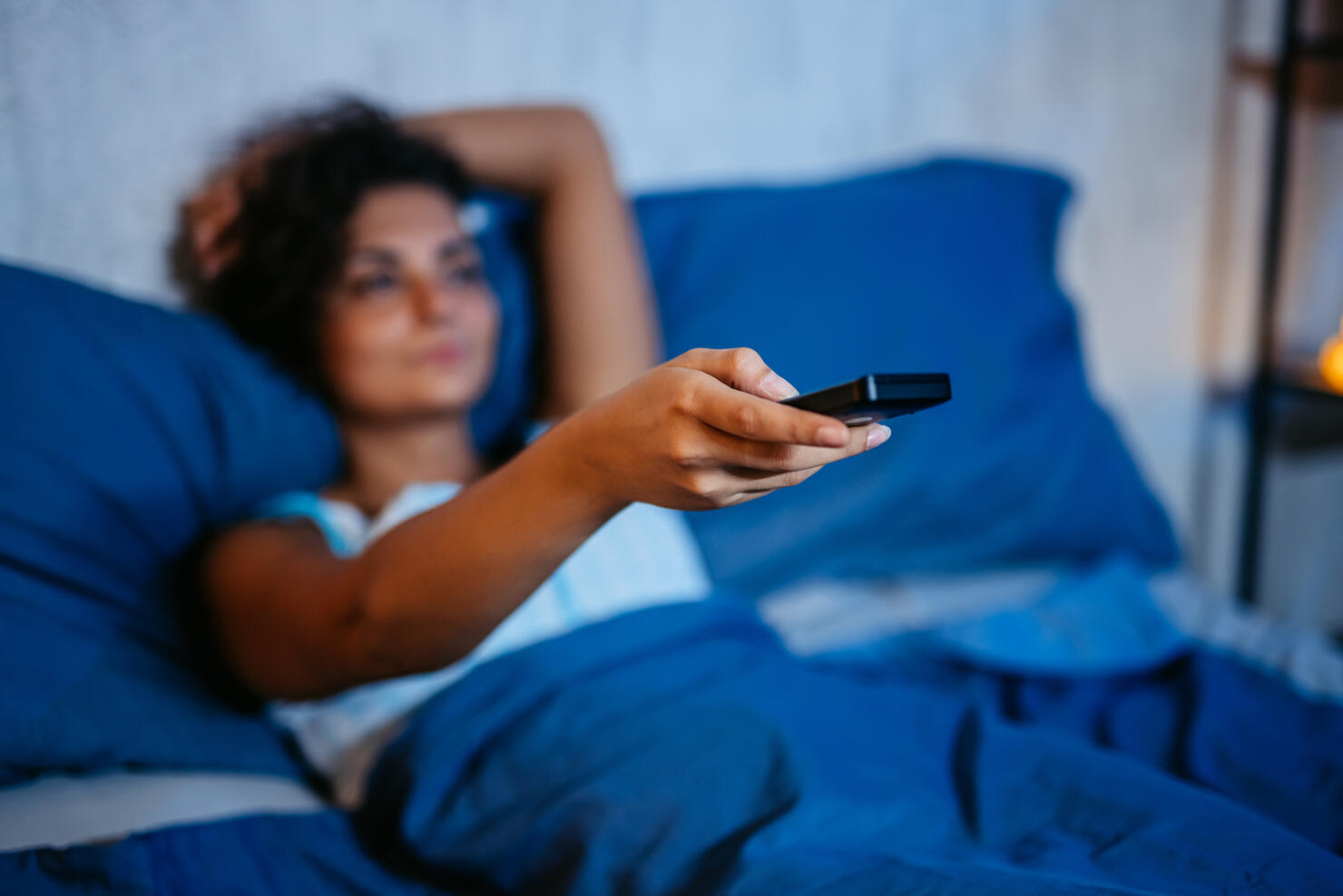 Young Woman Watching TV In The Bed At Night