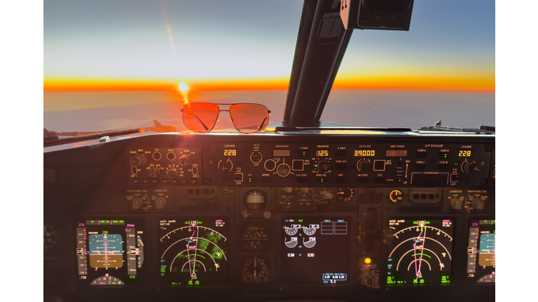 the autopilot mode control panel of an airplane and sunglasses with red rising sun