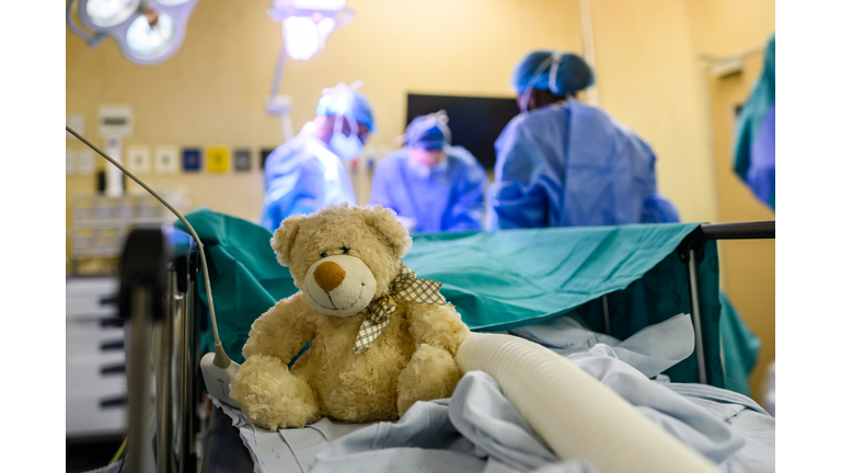 Comfort teddy bear on hospital bed during pediatric surgery setting