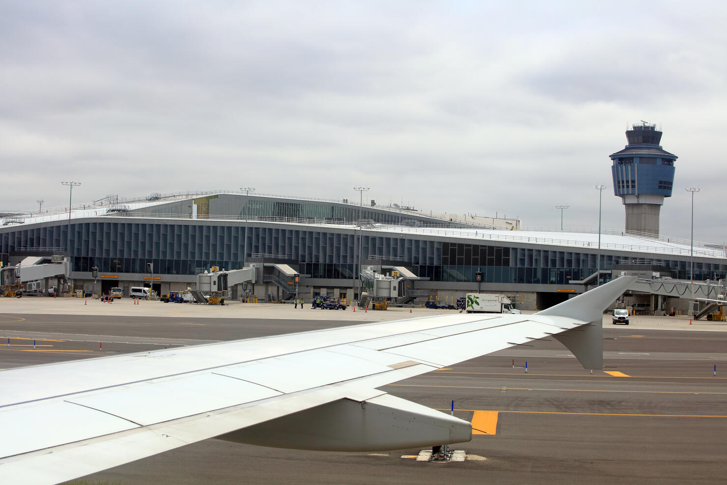 Plane landing at Laguardia airport, air traffic control tower in background - New York City, USA