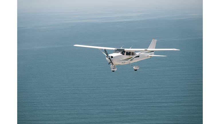 A light aircraft glides through the ocean