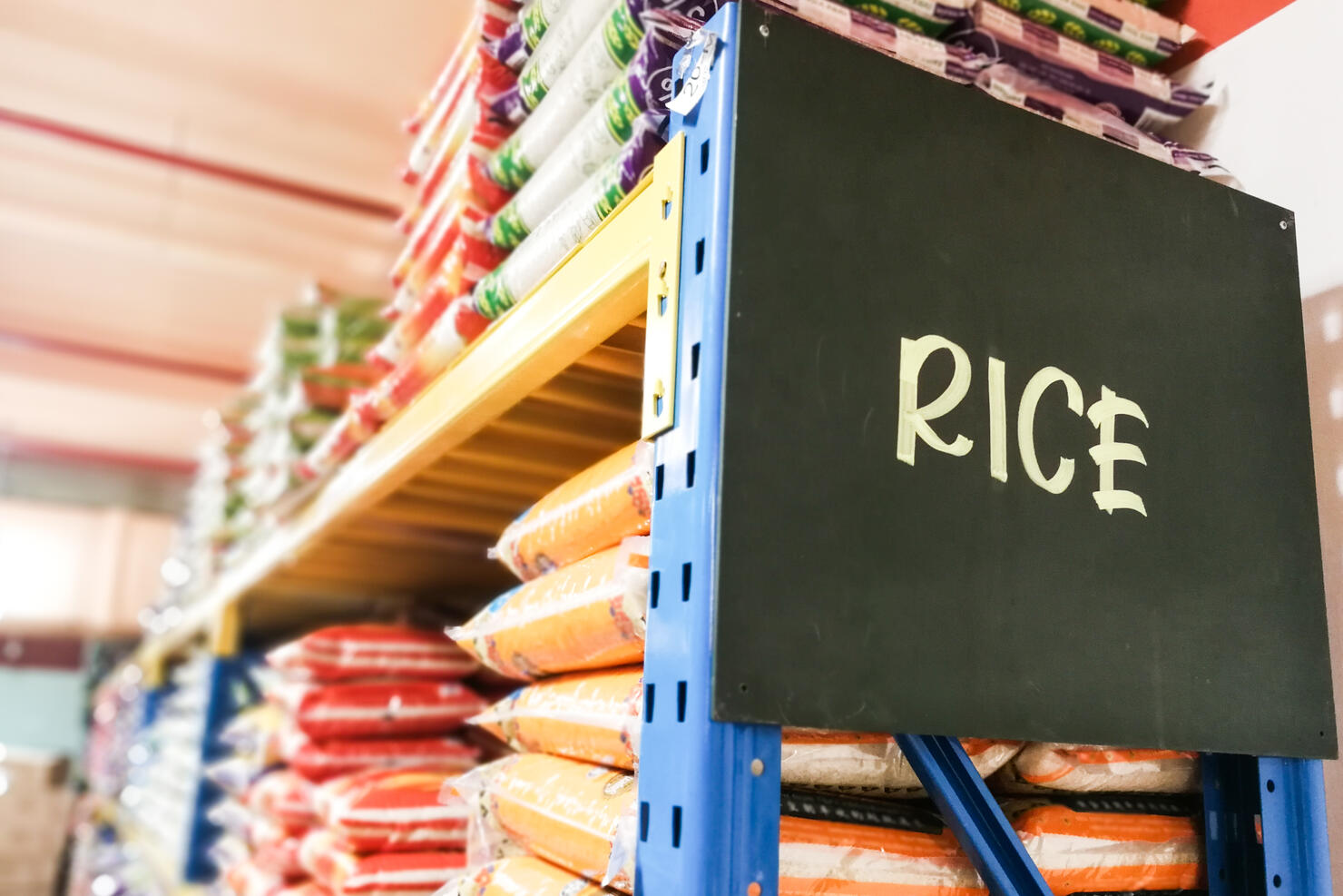 Rice signage with stacks of rice on shelf of supermarket