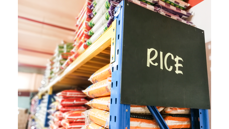 Rice signage with stacks of rice on shelf of supermarket
